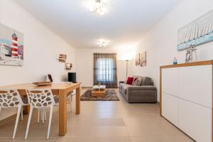 a kitchen and living room with a table and a couch at Rossio Sea View By ALzira in Albufeira