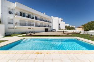 a house with a swimming pool in front of a building at Rossio Sea View By ALzira in Albufeira