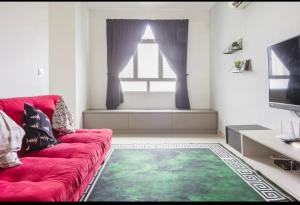 a living room with a red couch and a window at Spice Arena Guesthouse in Bayan Lepas