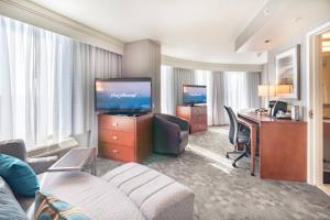 a hotel room with a desk and a living room at Courtyard by Marriott Silver Spring Downtown in Silver Spring