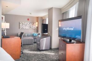 a living room with a large flat screen tv at Courtyard by Marriott Silver Spring Downtown in Silver Spring