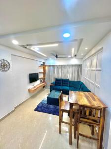 科爾瓦的住宿－Coco Loco Colva，客厅配有蓝色的沙发和桌子
