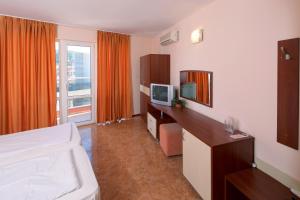 a hotel room with a bed and a television at Sunny Flower Family Hotel in Sunny Beach