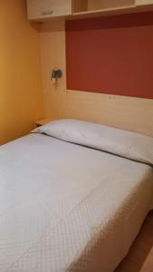 - une chambre avec un lit blanc et un mur rouge dans l'établissement Pozzo dei Desideri Appartamenti, à Peschici