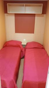 - 2 lits dans une petite chambre avec des draps rouges dans l'établissement Pozzo dei Desideri Appartamenti, à Peschici