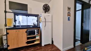 a kitchen with a refrigerator and a microwave at Mini Aps em Container na Meia Praia - Tetto 148 in Itapema