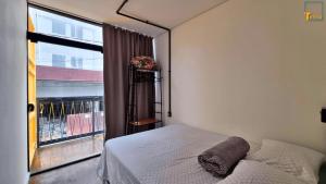 a bedroom with a bed and a large window at Mini Aps em Container na Meia Praia - Tetto 148 in Itapema