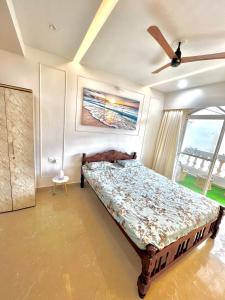 a bedroom with a bed and a ceiling fan at Coco Loco Colva in Colva