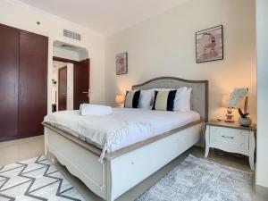 Un dormitorio con una gran cama blanca y una mesa en Key View - Time place en Dubái