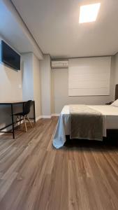 1 dormitorio con 1 cama y escritorio en una habitación en Hotel Diamante, en São Paulo
