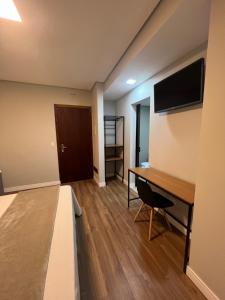 a room with a desk and a flat screen tv at Hotel Diamante in São Paulo