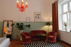 維也納的住宿－Romantic Urban Living，客厅配有椅子、桌子和吊灯。