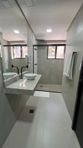 uma casa de banho branca com um lavatório e um chuveiro em Hotel Diamante em São Paulo