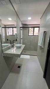 a white bathroom with a sink and a shower at Hotel Diamante in São Paulo