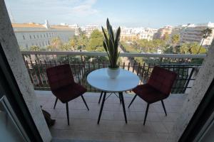 a table with two chairs and a plant on a balcony at L.T. BARI SUITE _ Locazioni Turistiche _ in Bari