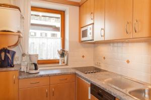 a kitchen with wooden cabinets and a sink and a window at Frühlingshof in Reit im Winkl