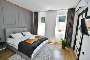 a bedroom with a large bed and a window at Nicole Apartment in Rijeka