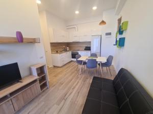 a living room with a table and chairs and a kitchen at Luxury Central Apartment One in Bacău