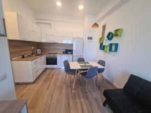 a kitchen and dining room with a table and chairs at Central EvaApartments One in Bacău