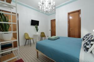 Un dormitorio con una cama azul y una lámpara de araña. en L.T. BARI SUITE _ Locazioni Turistiche _, en Bari