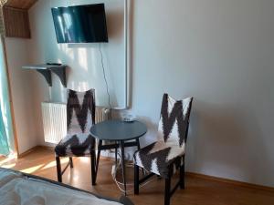 um quarto com uma mesa e duas cadeiras e uma televisão em Fiorita Vendégház em Eger