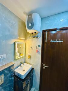 a bathroom with a sink and a wooden door at Frankstay By Hotel SAMRAT RESIDENCY 10 Mints Walking Distance Nizamuddin Railway Station in New Delhi