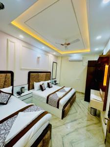 Habitación de hotel con 2 camas y lavamanos en Frankstay By Hotel SAMRAT RESIDENCY 10 Mints Walking Distance Nizamuddin Railway Station en Nueva Delhi