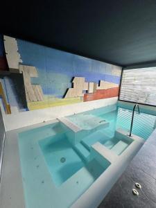 una grande piscina con un dipinto sul muro di Villa Moderna Exclusiva con Jardín Privado La Villa de Sevilla a Guillena Altre 44 foto