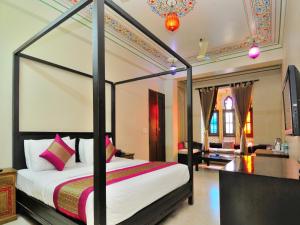 a bedroom with a four poster bed and a living room at Hotel Pinky Villa - Paharganj I New Delhi Railway Station in New Delhi