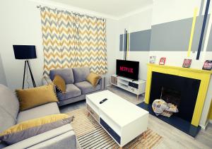 a living room with a couch and a fireplace at Must stay 3 Bedroom house near Greenwich and Blackheath- Ideal for families and contractors in London