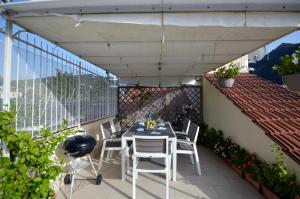 eine Terrasse mit einem Tisch und Stühlen auf dem Balkon in der Unterkunft La Terrazza Family Holidays, Sorrento Coast in Sant'Agnello