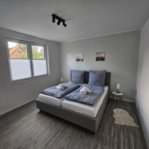 um quarto com uma cama com lençóis azuis e uma janela em Ferienwohnung - Melina - em Winsen