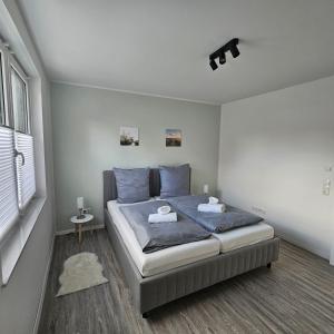 um quarto com uma cama com lençóis azuis e uma janela em Ferienwohnung - Melina - em Winsen