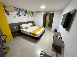 Habitación de hotel con cama y TV. en Hotel La Serrania Bucaramanga en Bucaramanga