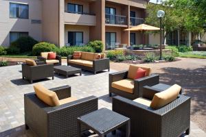 a patio with chairs and tables and a building at Courtyard St. Louis Creve Coeur in Creve Coeur