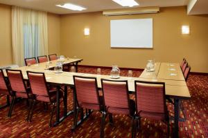 a conference room with tables and chairs and a whiteboard at Courtyard St. Louis Creve Coeur in Creve Coeur