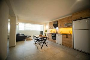 een keuken met een tafel met stoelen en een koelkast bij Nicholas Apartment Ölüdeniz in Fethiye