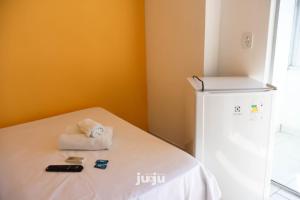 um quarto com uma cama e um pequeno frigorífico em Pousada Ju&Ju à 400 mts DA PRAIA em Pontal do Paraná