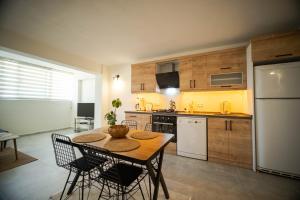 a kitchen with a table and chairs and a white refrigerator at 2BR Apartment in Ölüdeniz with Large Pool in Quiet Area in Fethiye
