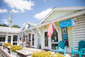 a store with two blue chairs on a porch at Chapel House in Pass Christian