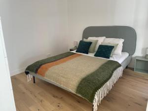 een slaapkamer met een groot bed met groene kussens bij La Villa Mandarine sur Arcachon in Arcachon