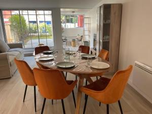 - une salle à manger avec une table et des chaises en bois dans l'établissement La Villa Mandarine sur Arcachon, à Arcachon