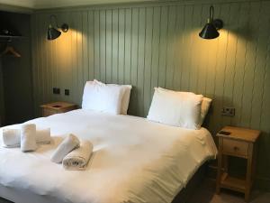 a large white bed with two towels on it at The Horse and Farrier Inn and The Salutation Inn Threlkeld Keswick in Threlkeld