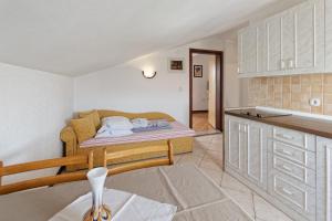 a small room with a bed and a kitchen at Apartments Exotica in Funtana
