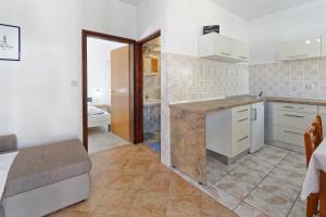 a kitchen with white cabinets and a counter top at Apartments Exotica in Funtana