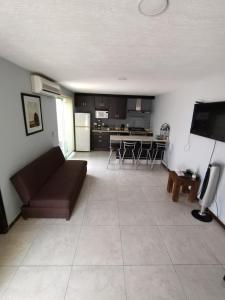 sala de estar con sofá marrón y cocina en Casa Cerca estadio Akron y plaza del sol, en Guadalajara