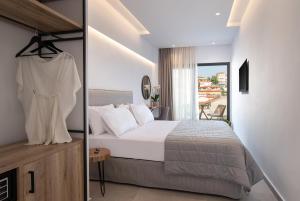a bedroom with a large bed and a balcony at G Mare Boutique Hotel in Neos Marmaras