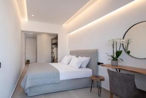 a bedroom with a bed and a desk and a mirror at G Mare Boutique Hotel in Neos Marmaras