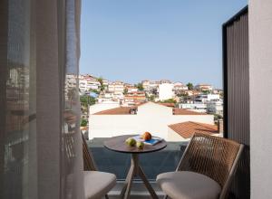 a balcony with a table and chairs and a view of a city at G Mare Boutique Hotel in Neos Marmaras