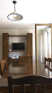 een eetkamer met een tafel en een televisie bij Casa Levante Gallipoli in Gallipoli